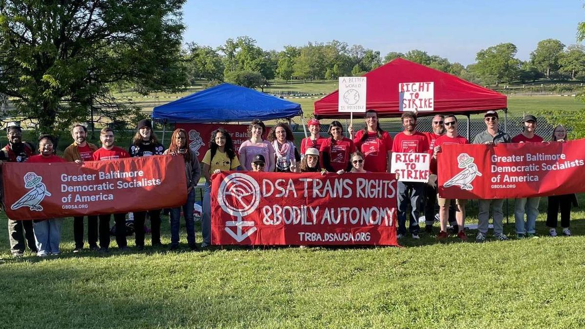 Group of GBDSA members holding banners for the chapter and for DSA Trans Rights & Bodily Autonomy