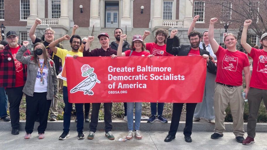 Group of members holding the GBDSA banner while raising their fist up in solidarity.