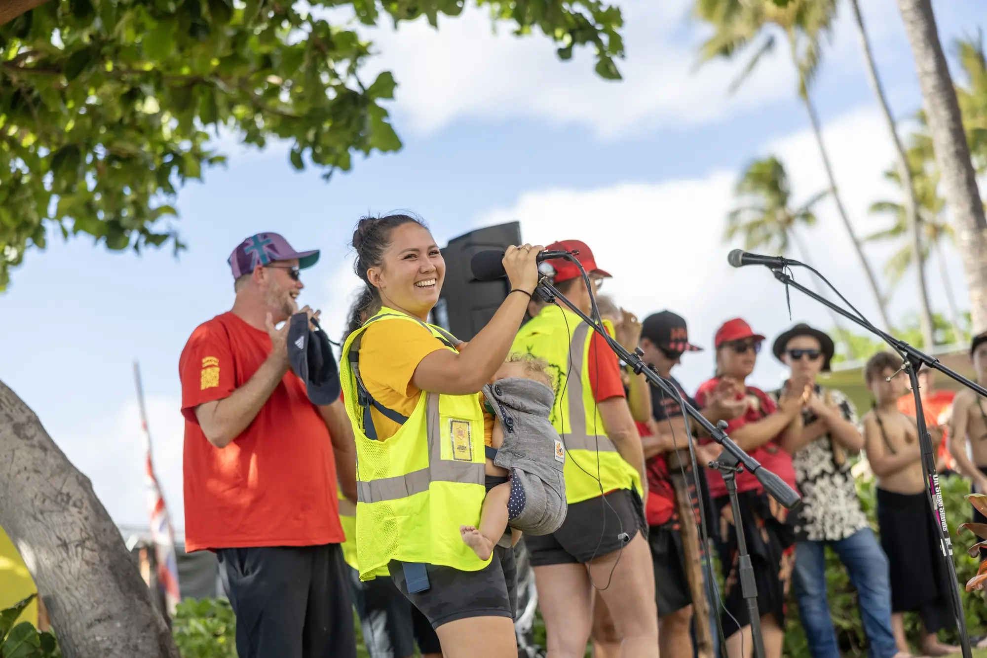 Lāhainā Strong volunteers in safety vests, smiling at a community event