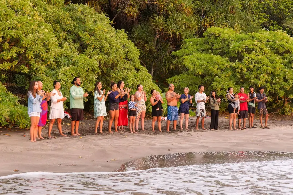 Community members gathered in a circle on the sand