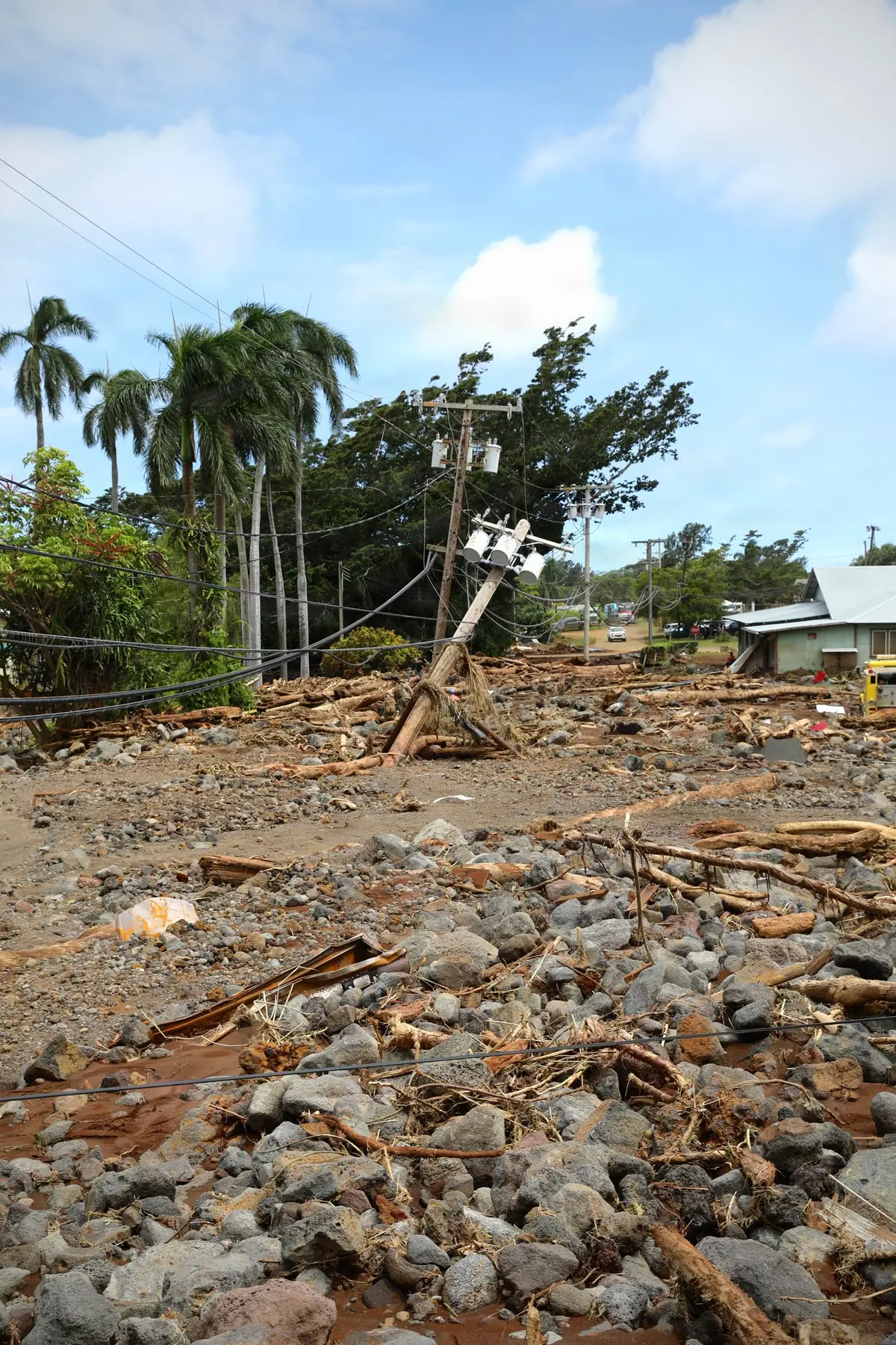 A downed power pole and homes surrounded by storm debris