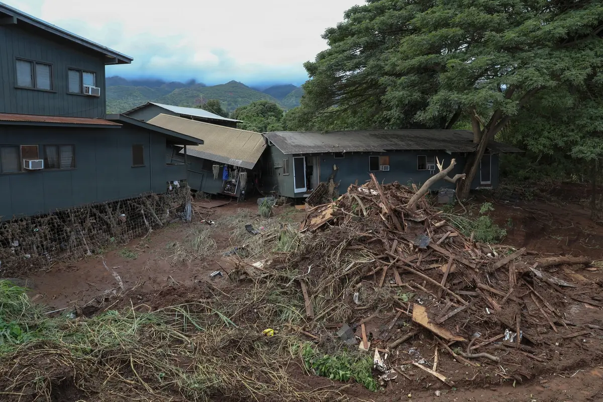 Flood debris piled against homes in Waialua