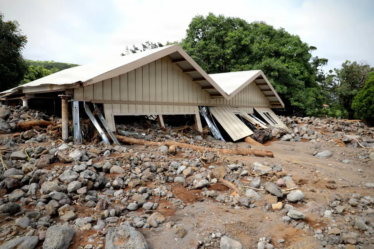 A home knocked off its foundation by mud and boulders in Nāʻālehu